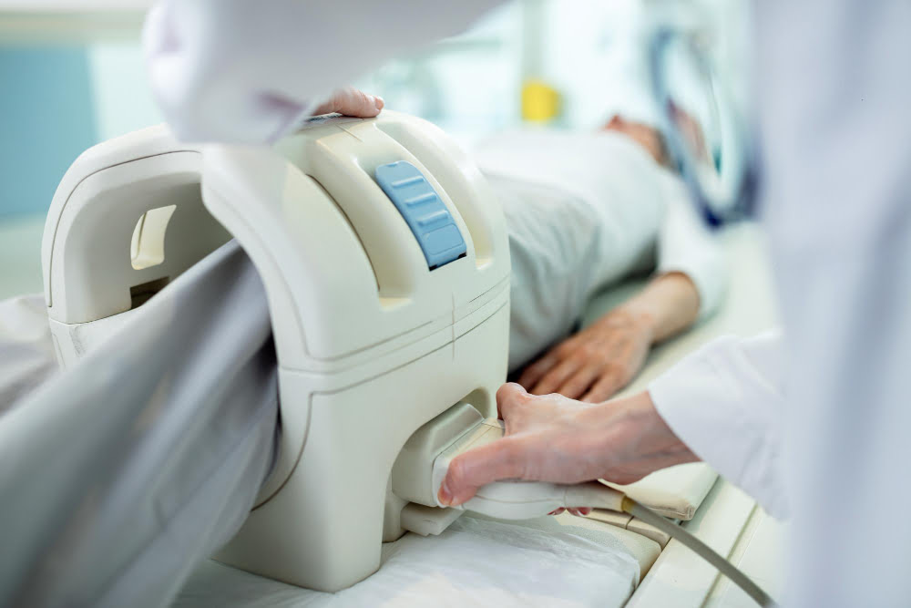 Exame de Imagem: Quais os mais comuns? 4 close up technician preparing patient knee mri scan procedure clinic